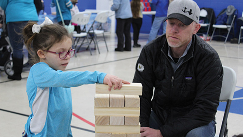Raia Koomen plays Jenga at the 2019 Winterfest with her dad, Jason.