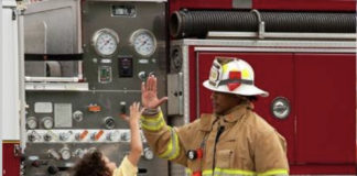 Firefighter high-fiving child.